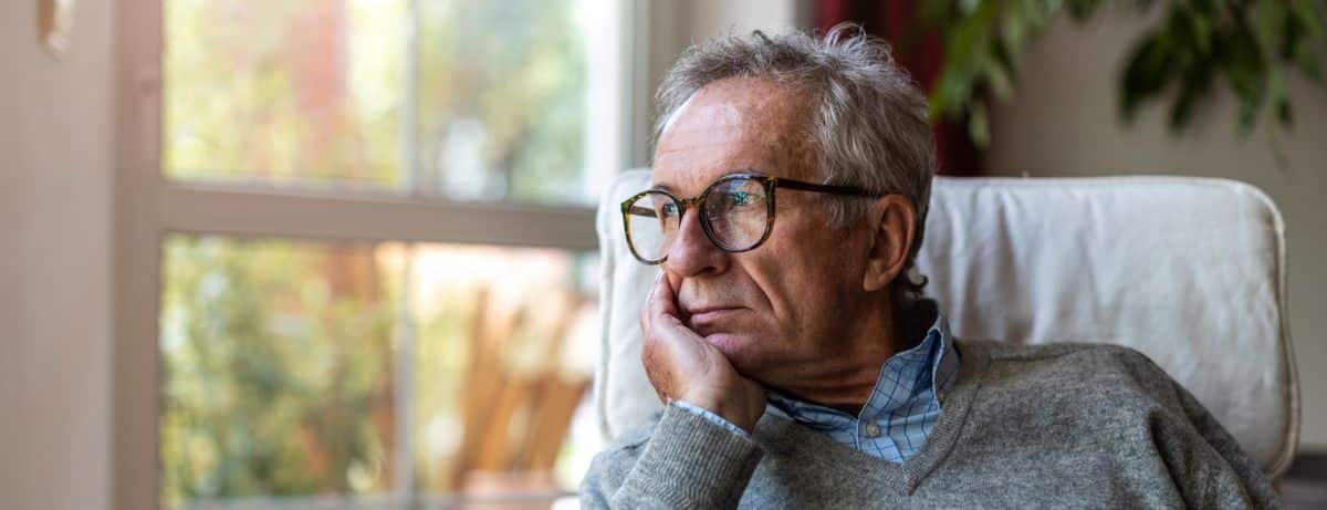 depressed older man gazing out window