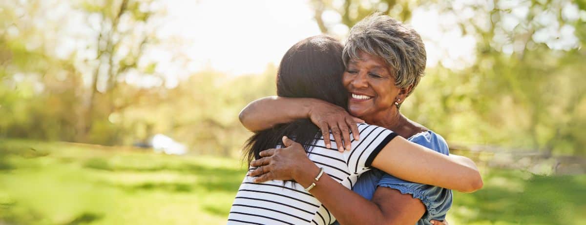 older woman hugging younger woman