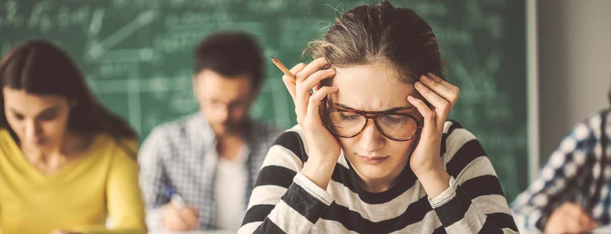 woman in classroom grasping head